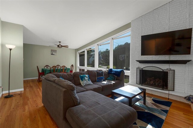 living room featuring a fireplace, vaulted ceiling, ceiling fan, and hardwood / wood-style flooring