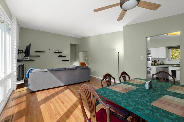 dining space featuring a healthy amount of sunlight, ceiling fan, and light hardwood / wood-style flooring