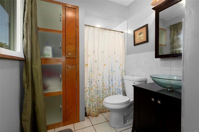 bathroom featuring tile walls, curtained shower, vanity, toilet, and tile patterned floors