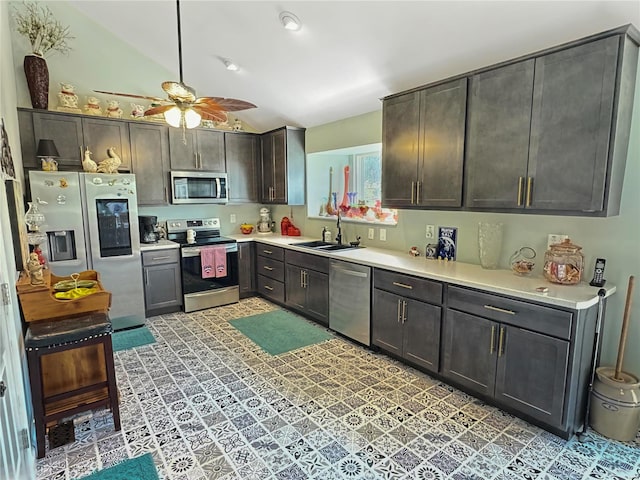 kitchen featuring vaulted ceiling, stainless steel appliances, dark brown cabinets, ceiling fan, and sink