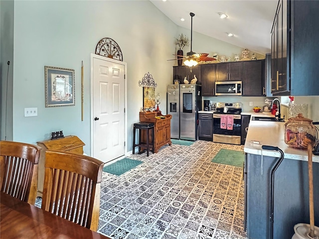 kitchen featuring appliances with stainless steel finishes, hanging light fixtures, high vaulted ceiling, ceiling fan, and sink