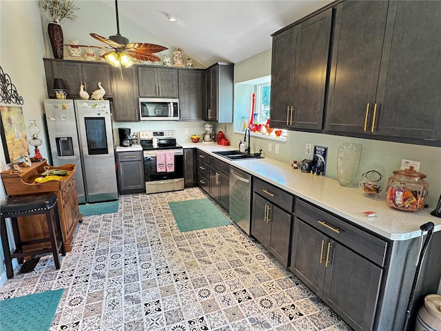 kitchen with dark brown cabinets, sink, vaulted ceiling, stainless steel appliances, and ceiling fan