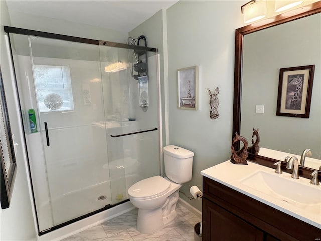 bathroom featuring vanity, toilet, and a shower with shower door