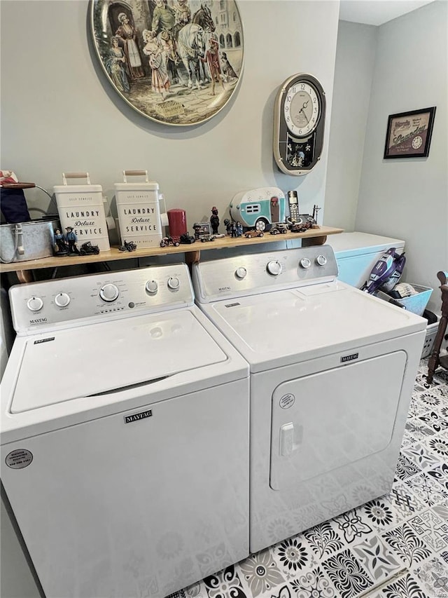 clothes washing area featuring light tile patterned floors and washing machine and dryer