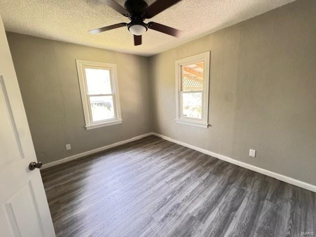 empty room featuring a textured ceiling, dark wood-type flooring, and ceiling fan