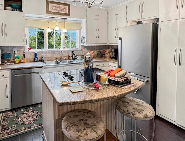 kitchen featuring white cabinets, stainless steel appliances, and an inviting chandelier