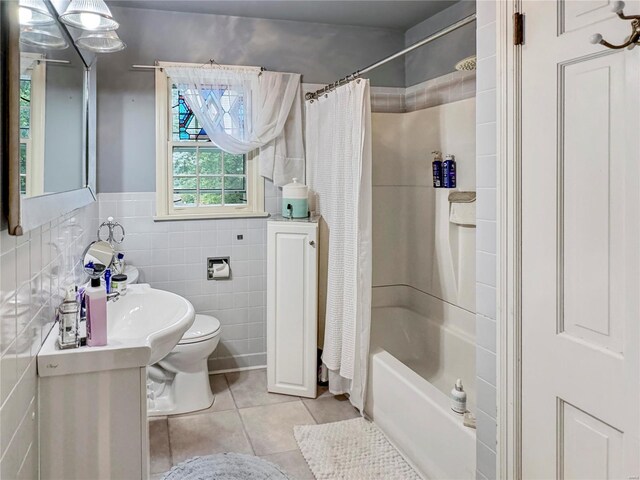 bathroom featuring tile walls, shower / bath combination with curtain, toilet, and tile patterned floors