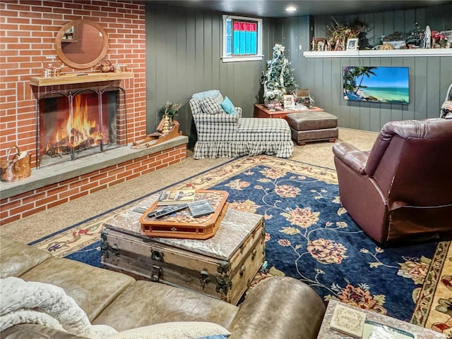 living room featuring a brick fireplace, wooden walls, and carpet floors