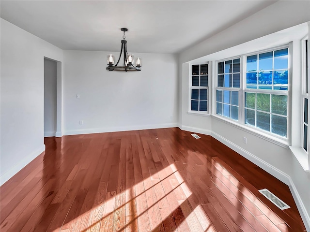 unfurnished dining area featuring hardwood / wood-style floors and a notable chandelier