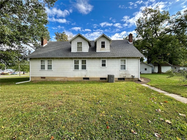 rear view of house with a lawn and central AC