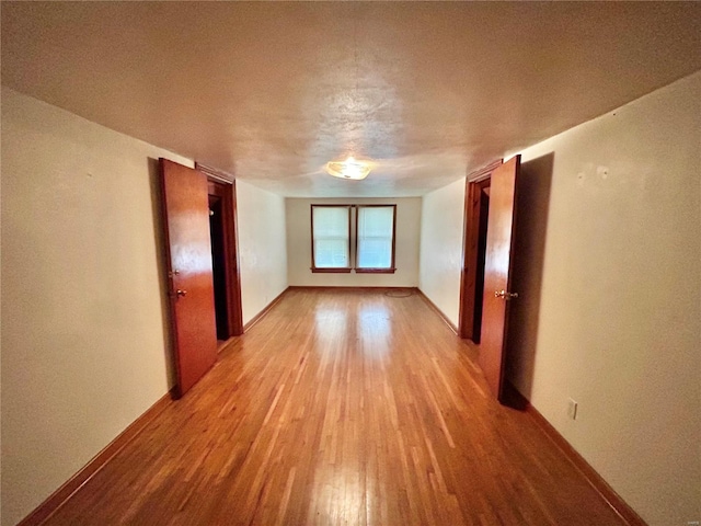 empty room featuring light hardwood / wood-style floors and a textured ceiling