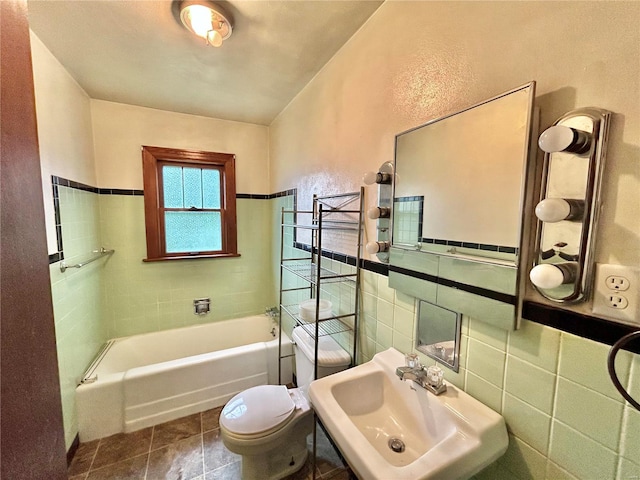 full bathroom featuring tile walls, toilet, shower / washtub combination, and sink