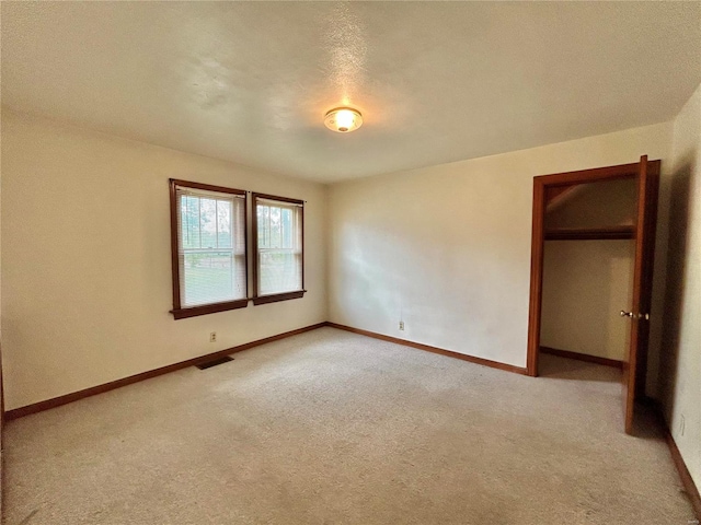 unfurnished bedroom with a textured ceiling and light colored carpet