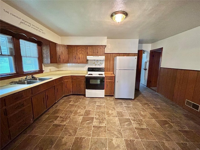 kitchen featuring white appliances, sink, and a textured ceiling