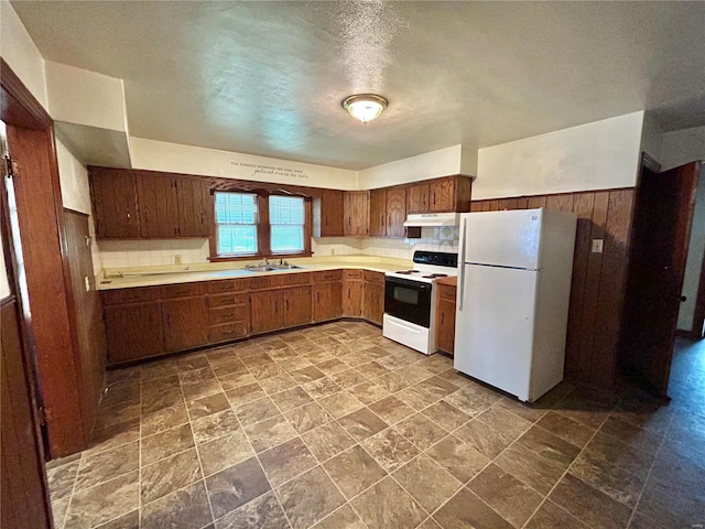 kitchen featuring white appliances, a textured ceiling, and sink