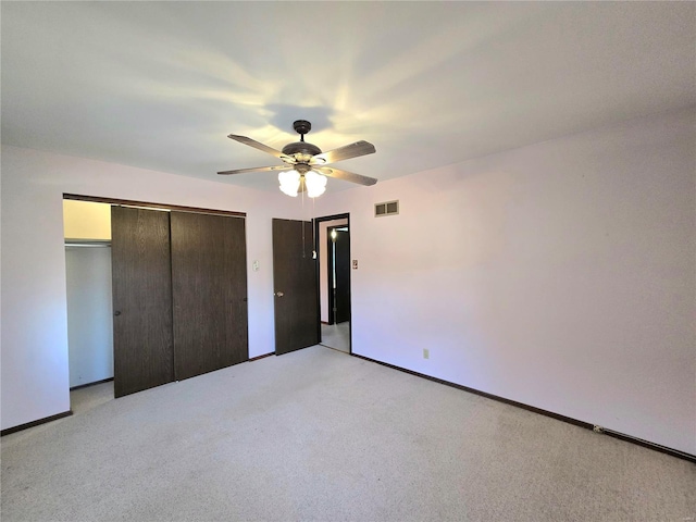 unfurnished bedroom featuring light carpet, ceiling fan, and a closet