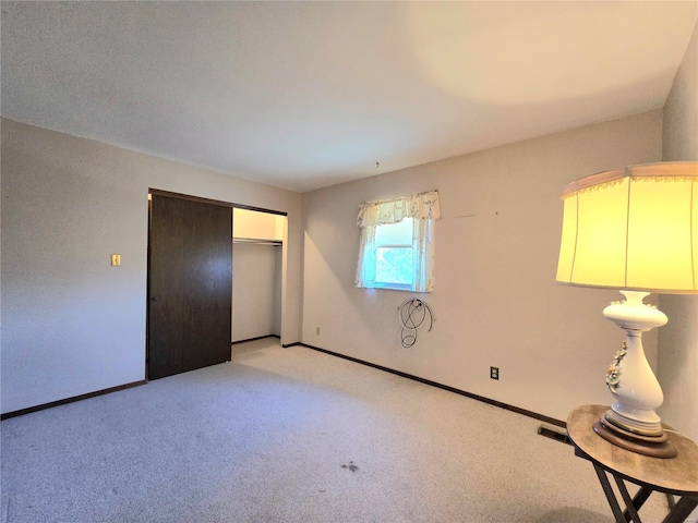 unfurnished bedroom with a closet and light carpet