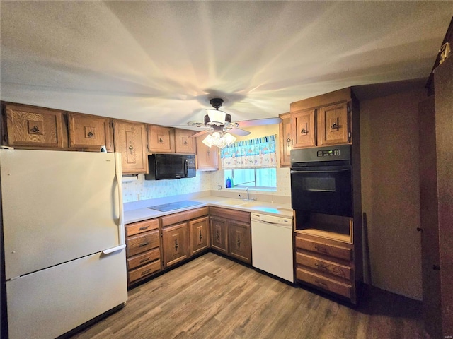 kitchen featuring ceiling fan, light hardwood / wood-style floors, a textured ceiling, and black appliances