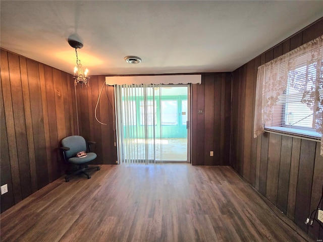 unfurnished room featuring a healthy amount of sunlight, wooden walls, and hardwood / wood-style floors