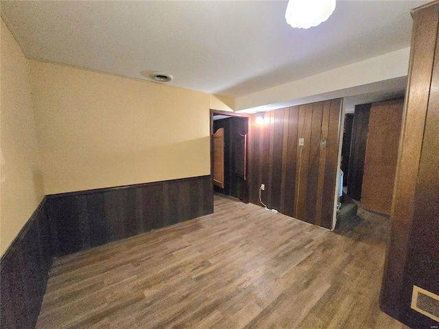 empty room featuring hardwood / wood-style flooring and wooden walls