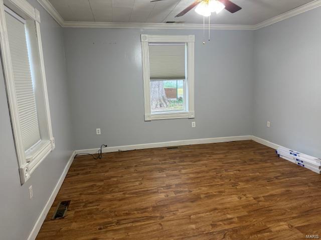 empty room featuring ceiling fan, dark hardwood / wood-style floors, and ornamental molding