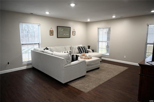 living room featuring dark wood-type flooring and a healthy amount of sunlight