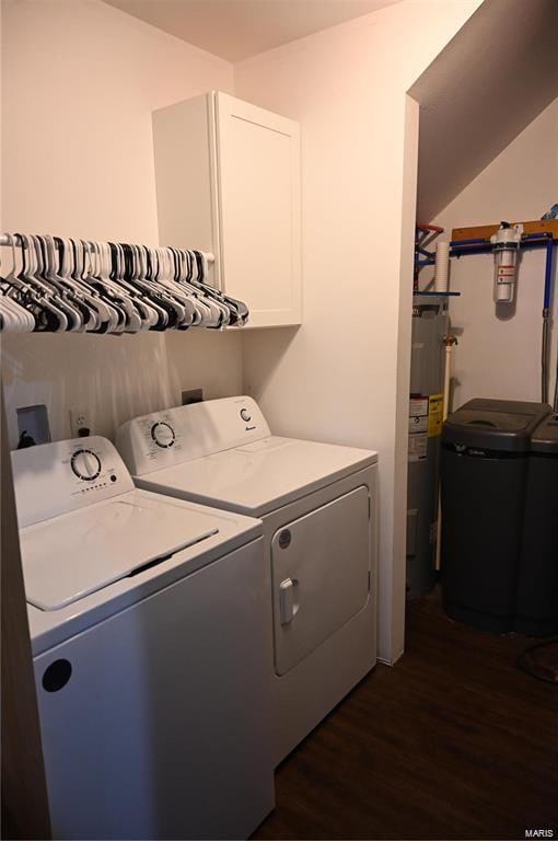 laundry room with electric water heater, dark hardwood / wood-style flooring, cabinets, and washing machine and dryer