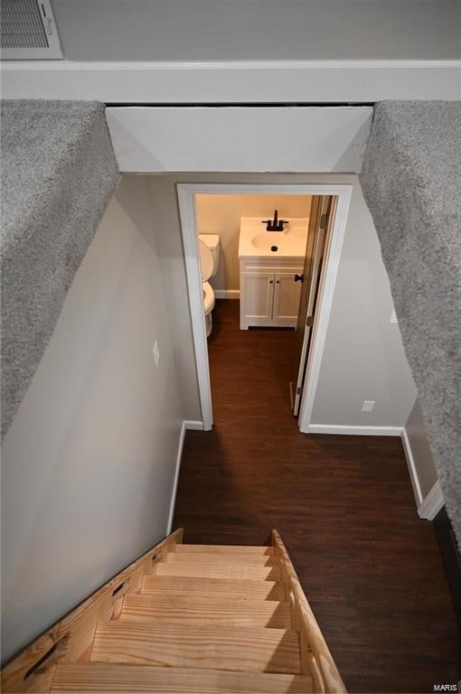 staircase with sink and hardwood / wood-style floors