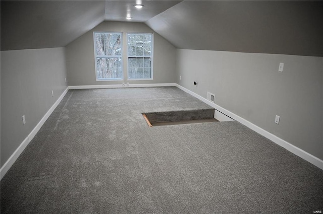 bonus room with vaulted ceiling and carpet flooring