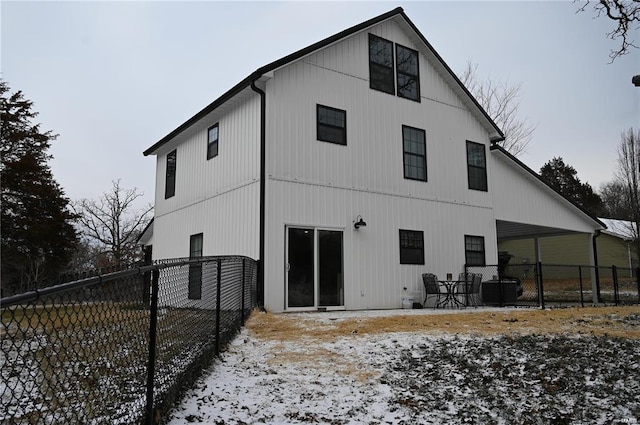 snow covered house featuring a patio