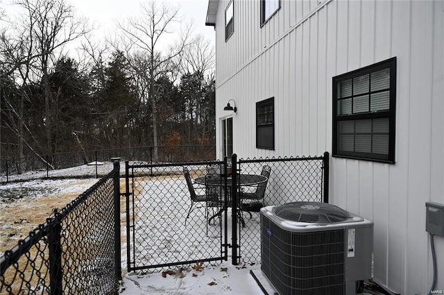 snow covered patio featuring central AC