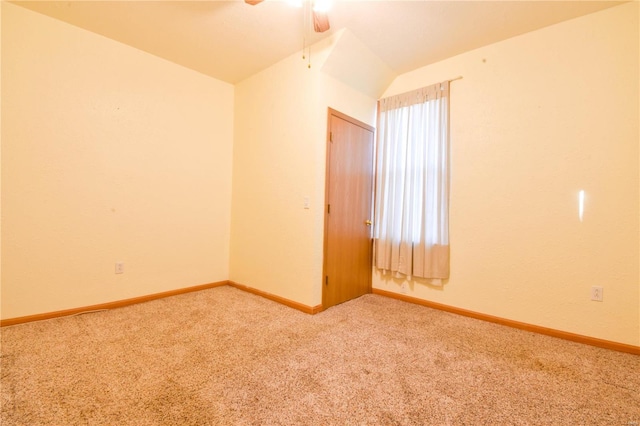 carpeted spare room featuring ceiling fan and lofted ceiling