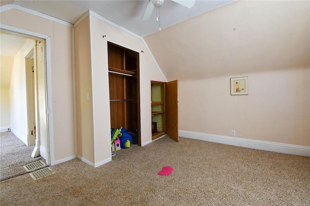 unfurnished bedroom with carpet flooring, ceiling fan, and vaulted ceiling