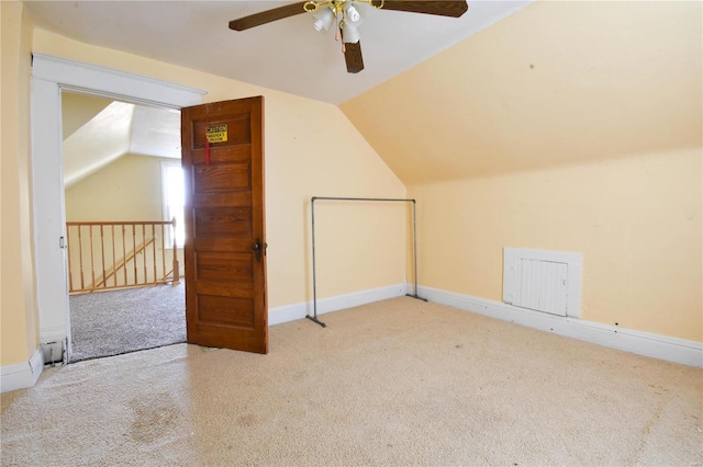 additional living space featuring light colored carpet, ceiling fan, and lofted ceiling