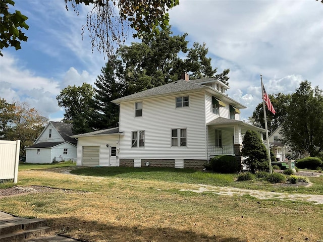 rear view of house with a garage, a porch, and a yard