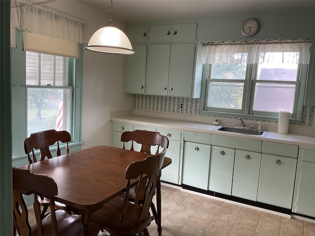 kitchen with decorative light fixtures, sink, tasteful backsplash, and a healthy amount of sunlight