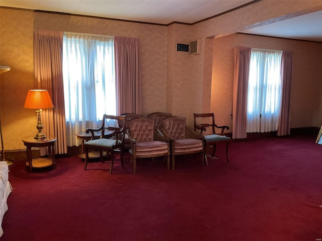 living area with a wealth of natural light, carpet flooring, and crown molding