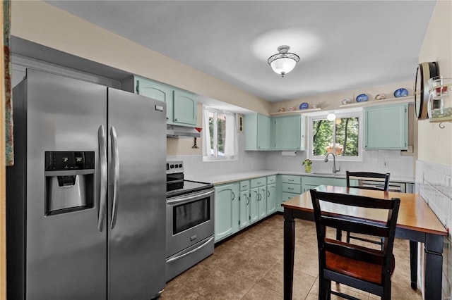 kitchen with appliances with stainless steel finishes, decorative backsplash, sink, and a healthy amount of sunlight