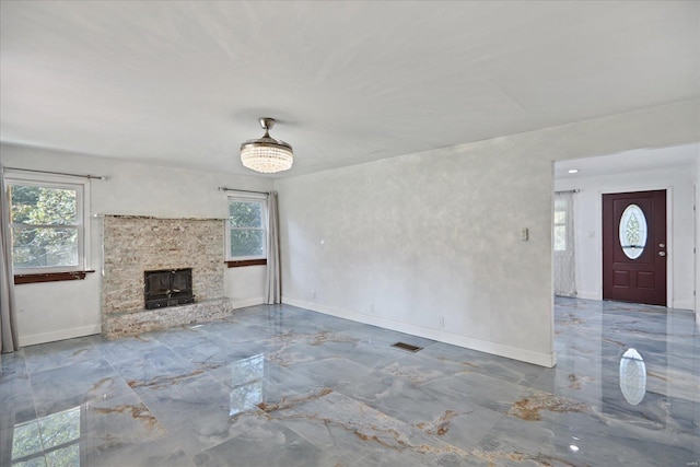 unfurnished living room featuring a fireplace and plenty of natural light