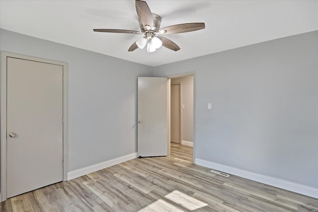 empty room with ceiling fan and light hardwood / wood-style flooring