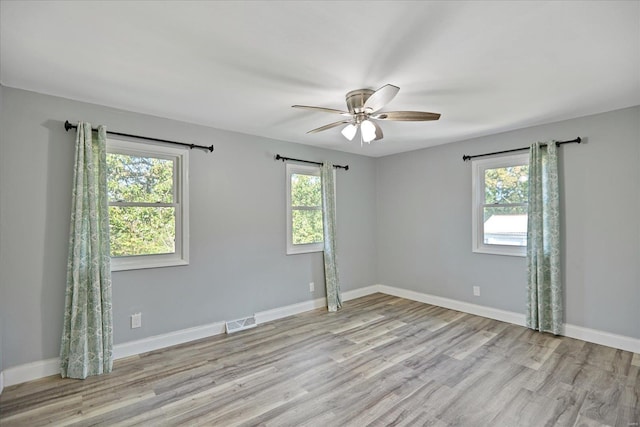 unfurnished room featuring ceiling fan, light hardwood / wood-style flooring, and a wealth of natural light