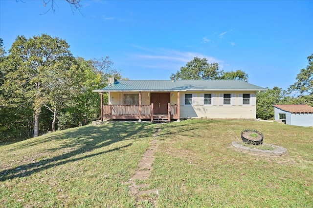 view of front facade featuring a front yard, a fire pit, and a wooden deck