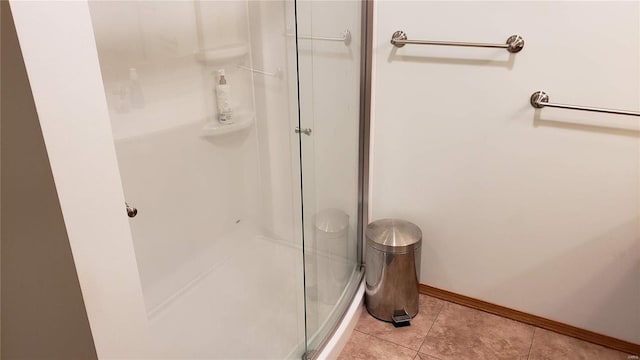 bathroom with a shower with shower door and tile patterned flooring