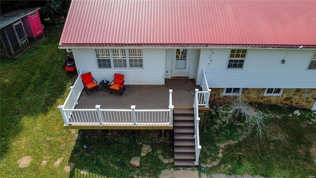 back of house featuring a deck and a lawn