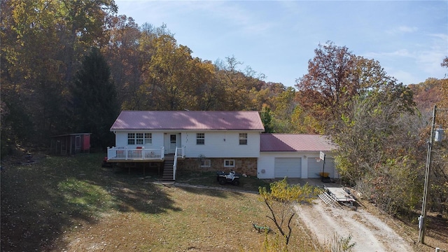 view of front of house featuring a wooden deck, a front yard, and a garage