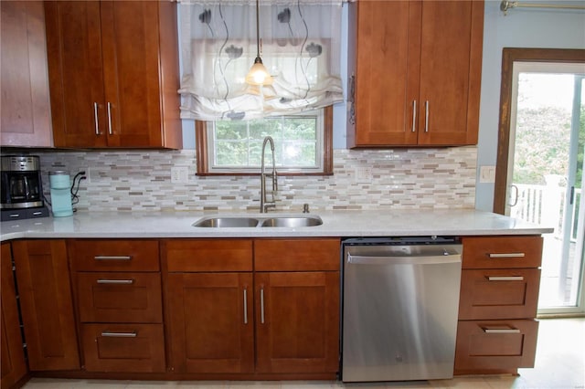 kitchen featuring dishwasher, a healthy amount of sunlight, sink, and hanging light fixtures