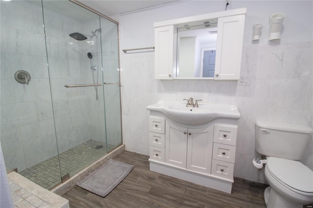 bathroom featuring toilet, vanity, hardwood / wood-style floors, tile walls, and walk in shower