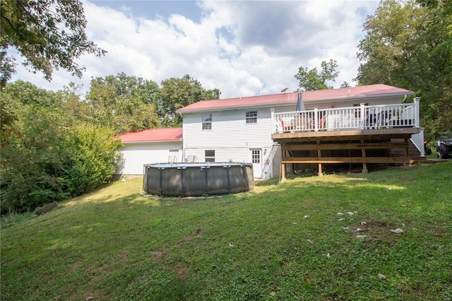 back of property with a swimming pool side deck and a lawn