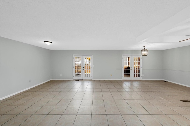 tiled empty room featuring french doors, a textured ceiling, and ceiling fan with notable chandelier