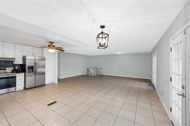 kitchen featuring decorative backsplash, white cabinets, appliances with stainless steel finishes, light tile patterned flooring, and pendant lighting